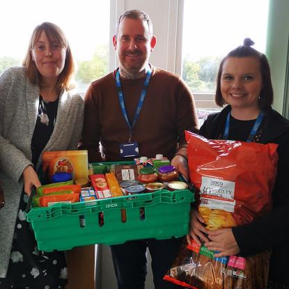 Staff at Housing Plus Group are pictured with donations to local food banks